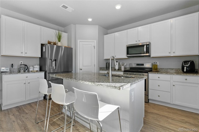 kitchen with light wood-style flooring, visible vents, appliances with stainless steel finishes, and a sink