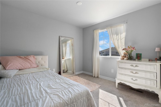 bedroom with baseboards and light colored carpet