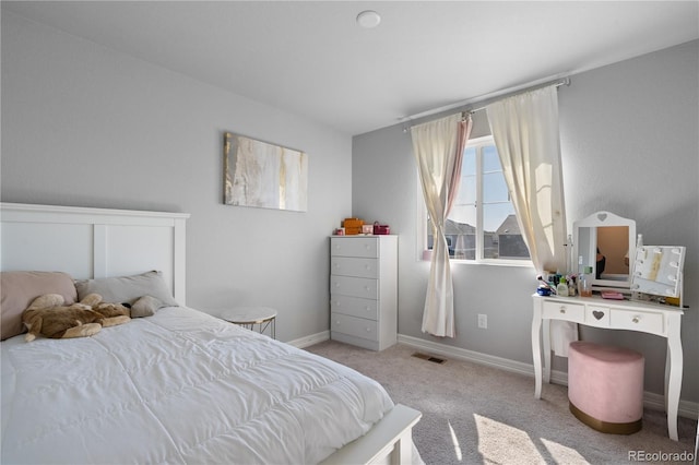 carpeted bedroom featuring baseboards and visible vents