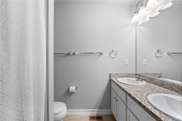 bathroom with a sink, visible vents, baseboards, and double vanity