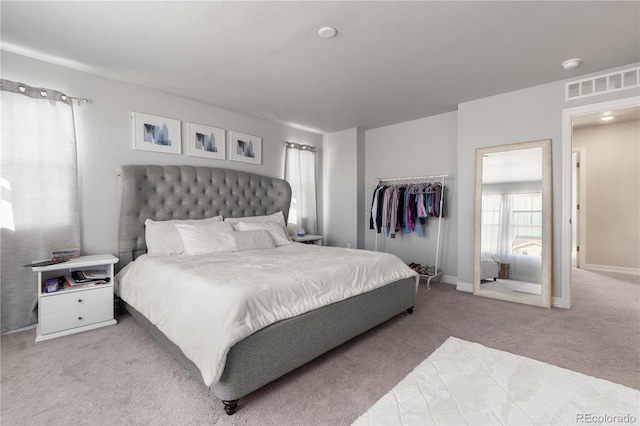 carpeted bedroom with visible vents and baseboards