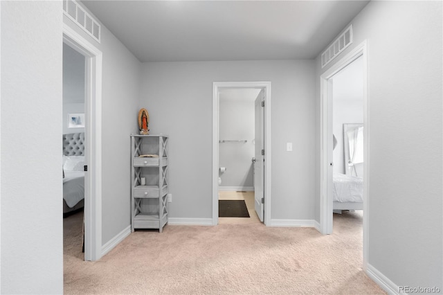 unfurnished bedroom featuring visible vents, baseboards, ensuite bathroom, and carpet flooring