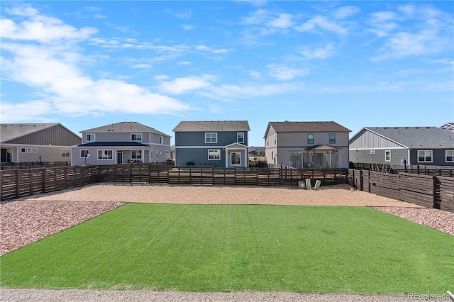 view of yard featuring a residential view, an enclosed area, and fence