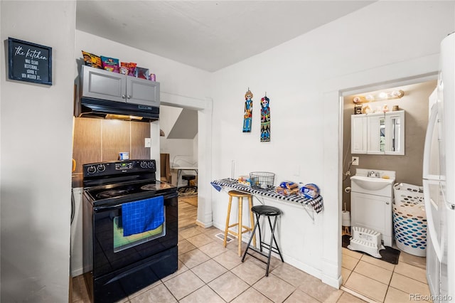 609 W 8th St Unit 611, Pueblo, CO 81003 - kitchen with black electric range oven, light tile patterned floors, under cabinet range hood, and a sink