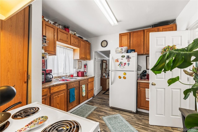 609 W 8th St Unit 611, Pueblo, CO 81003 - kitchen with white appliances, brown cabinets, dark wood-type flooring, and a sink