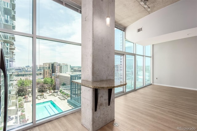 1700 Bassett St Unit 1102, Denver, CO 80202 - interior space featuring a wall of windows, wood finished floors, a view of city, and baseboards