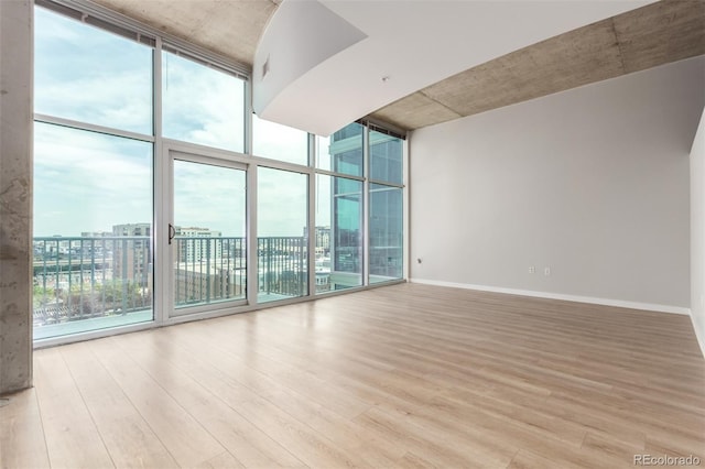 1700 Bassett St Unit 1102, Denver, CO 80202 - empty room with expansive windows, wood finished floors, and baseboards