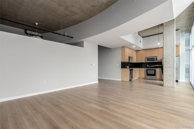 1700 Bassett St Unit 1102, Denver, CO 80202 - unfurnished living room with light wood-style floors and baseboards