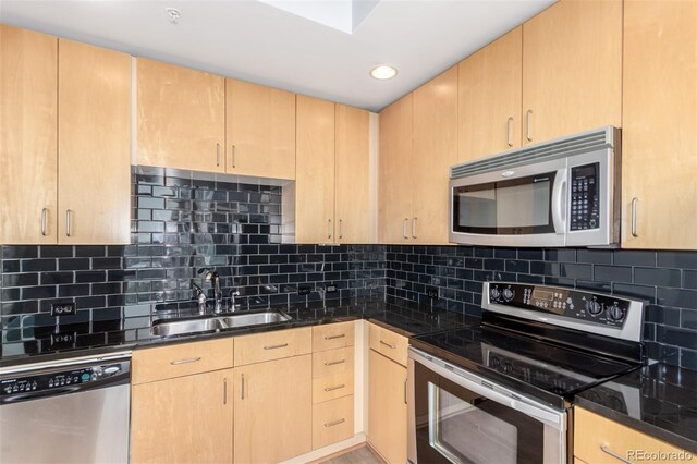 1700 Bassett St Unit 1102, Denver, CO 80202 - kitchen featuring stainless steel appliances, a sink, light brown cabinets, tasteful backsplash, and dark stone counters