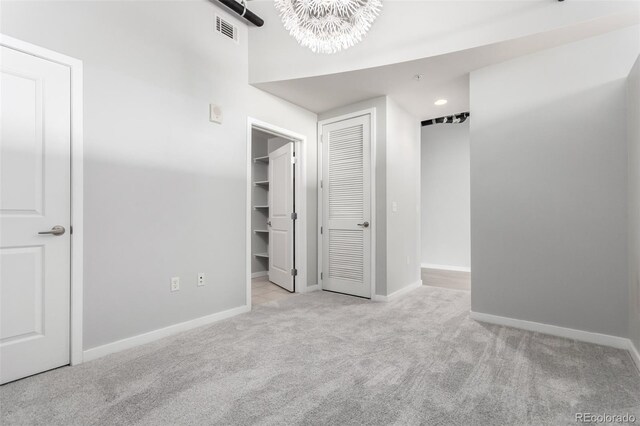 1700 Bassett St Unit 1102, Denver, CO 80202 - unfurnished bedroom featuring carpet flooring, a chandelier, baseboards, a spacious closet, and recessed lighting