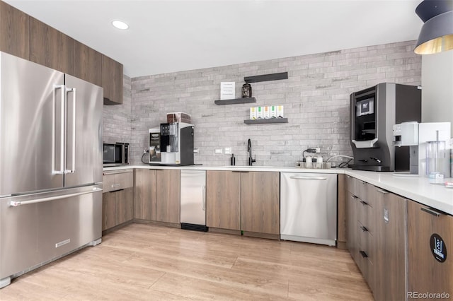 1700 Bassett St Unit 1102, Denver, CO 80202 - kitchen with stainless steel appliances, a sink, tasteful backsplash, light countertops, and recessed lighting