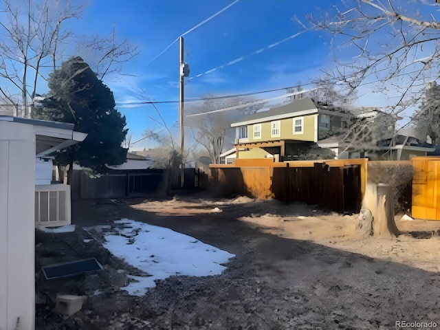 snowy yard featuring fence