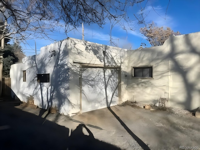 view of snowy exterior with a mountain view and stucco siding