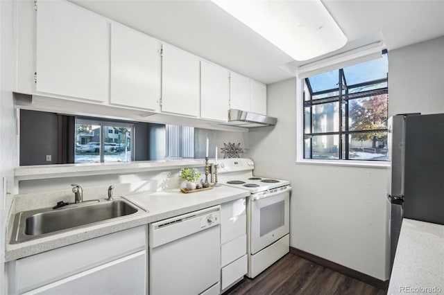 kitchen with dark wood-type flooring, sink, white appliances, and white cabinetry