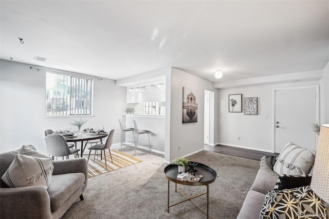 living room featuring carpet, baseboards, and visible vents