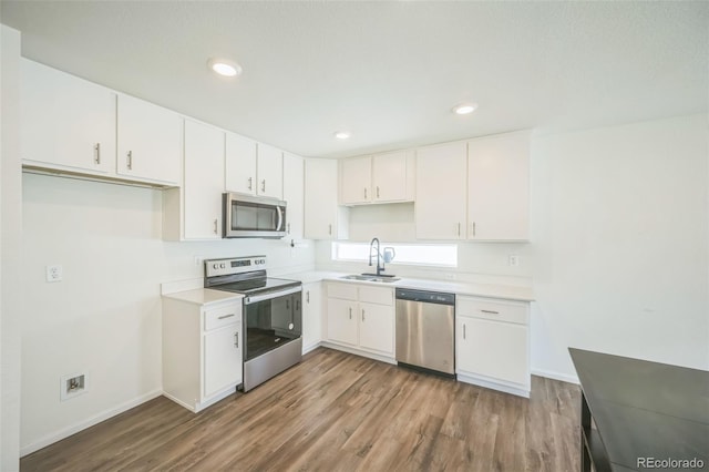 18211 E 51st Ave, Denver, CO 80249 - kitchen featuring stainless steel appliances, a sink, wood finished floors, baseboards, and recessed lighting