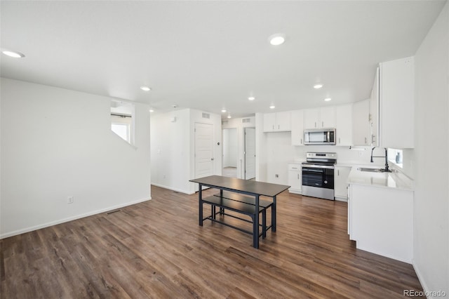 18211 E 51st Ave, Denver, CO 80249 - kitchen featuring stainless steel appliances, a sink, dark wood-type flooring, recessed lighting, and white cabinetry