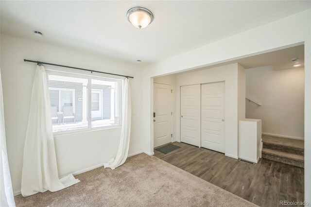 18211 E 51st Ave, Denver, CO 80249 - unfurnished bedroom with a closet, baseboards, wood finished floors, and carpet flooring
