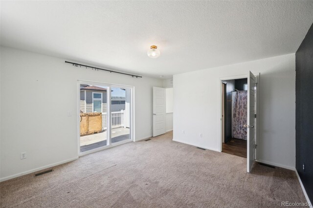 18211 E 51st Ave, Denver, CO 80249 - unfurnished bedroom featuring access to outside, carpet floors, baseboards, and a textured ceiling