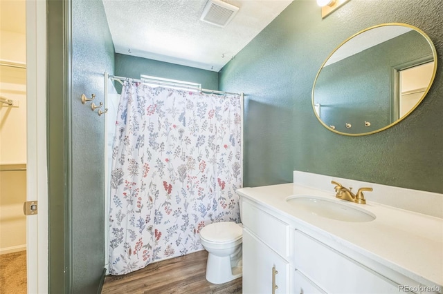 18211 E 51st Ave, Denver, CO 80249 - full bathroom with wood finished floors, vanity, toilet, a shower with shower curtain, and a textured wall
