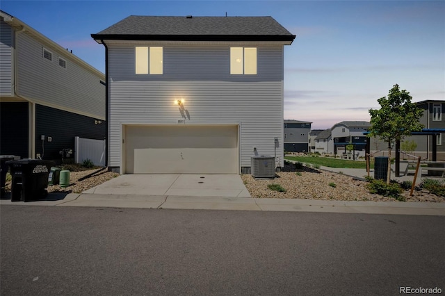 18211 E 51st Ave, Denver, CO 80249 - view of front facade featuring a garage, concrete driveway, central air condition unit, and a shingled roof