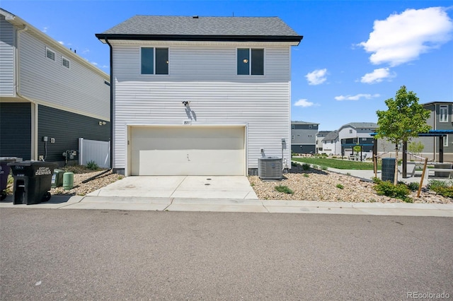 18211 E 51st Ave, Denver, CO 80249 - view of front of house featuring a garage, concrete driveway, central AC unit, and a residential view