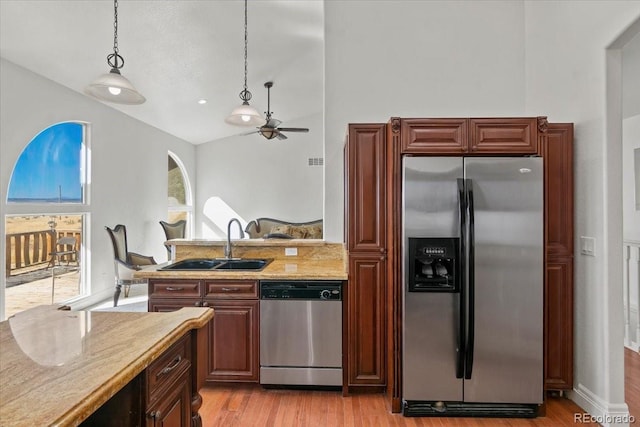 kitchen featuring ceiling fan, sink, stainless steel appliances, decorative light fixtures, and light wood-type flooring