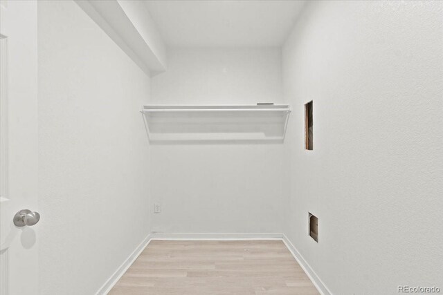 clothes washing area featuring light wood-type flooring