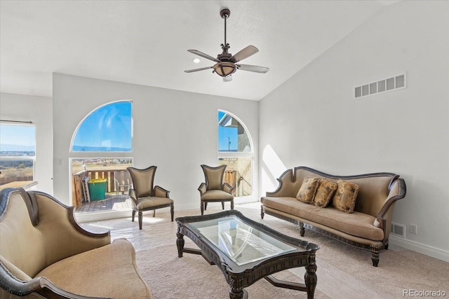 living room featuring ceiling fan, light carpet, and vaulted ceiling