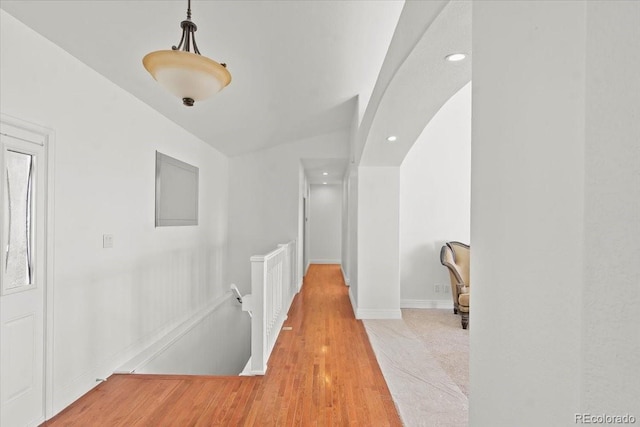 corridor with vaulted ceiling and light wood-type flooring