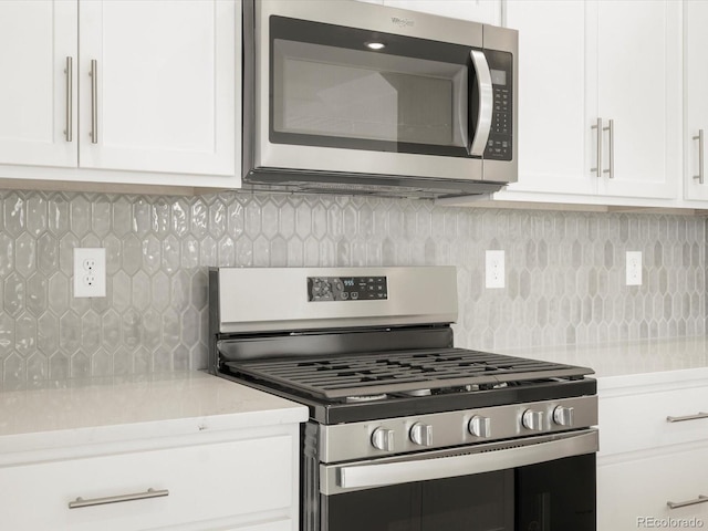 kitchen with white cabinetry, backsplash, and appliances with stainless steel finishes