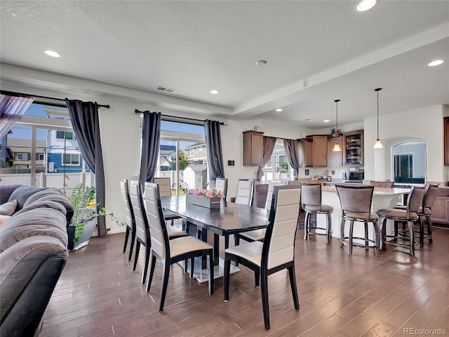 19155 Robins Dr, Denver, CO 80249 - dining room with dark wood finished floors, arched walkways, recessed lighting, and a textured ceiling