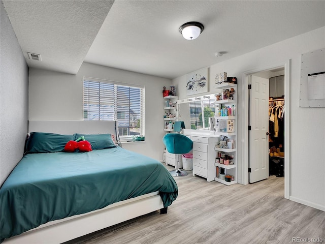 19155 Robins Dr, Denver, CO 80249 - bedroom with wood finished floors, a spacious closet, and a textured ceiling