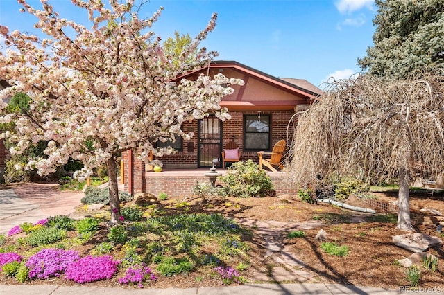 view of front of property featuring brick siding and covered porch