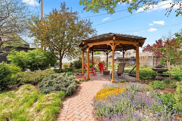view of patio with fence, a gazebo, and a fire pit