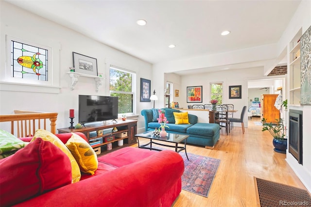 living room with recessed lighting, wood finished floors, and visible vents