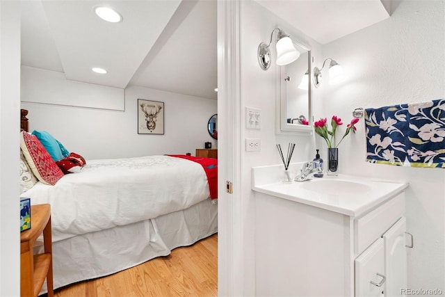 bedroom featuring recessed lighting, a sink, and wood finished floors