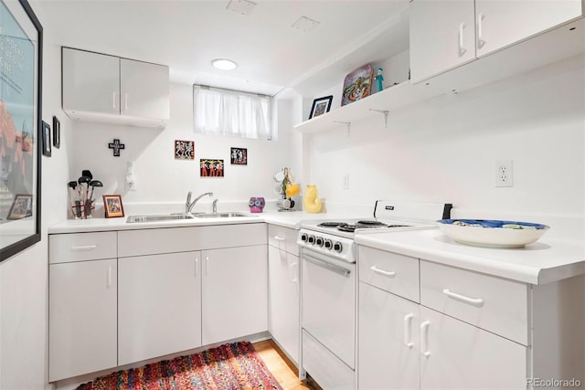 kitchen featuring white electric range, a sink, white cabinetry, and light countertops