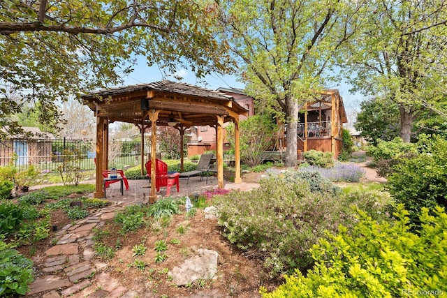 view of yard with a gazebo, a ceiling fan, fence, and a patio