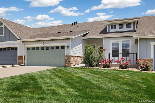 14443 W 88th Dr Unit B, Arvada, CO 80005 - view of front of house with stone siding, board and batten siding, a front yard, driveway, and an attached garage