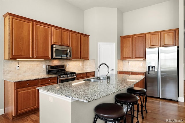 14443 W 88th Dr Unit B, Arvada, CO 80005 - kitchen with stainless steel appliances, dark wood-type flooring, light stone counters, and a towering ceiling