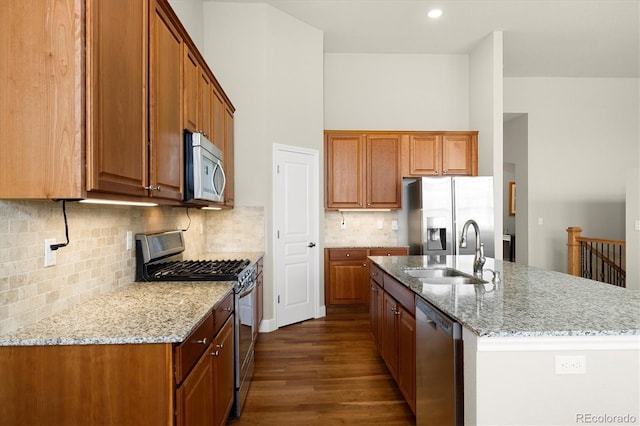 14443 W 88th Dr Unit B, Arvada, CO 80005 - kitchen with appliances with stainless steel finishes, dark wood finished floors, brown cabinets, and light stone counters