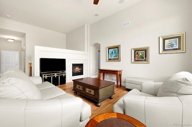 14443 W 88th Dr Unit B, Arvada, CO 80005 - living area with wood finished floors, arched walkways, a glass covered fireplace, and ceiling fan