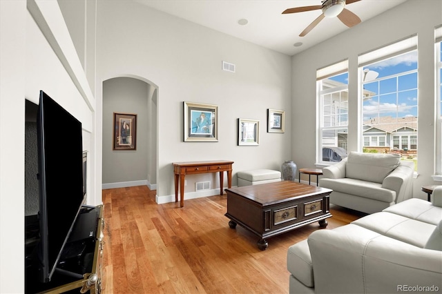 14443 W 88th Dr Unit B, Arvada, CO 80005 - living room with arched walkways, ceiling fan, and light wood-style floors