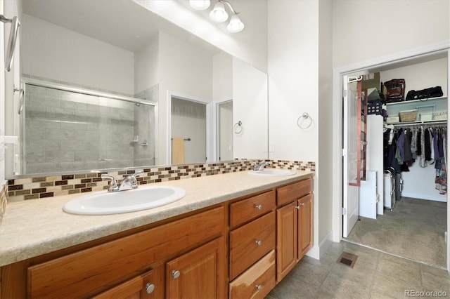 14443 W 88th Dr Unit B, Arvada, CO 80005 - bathroom with double vanity, a shower stall, a walk in closet, and decorative backsplash