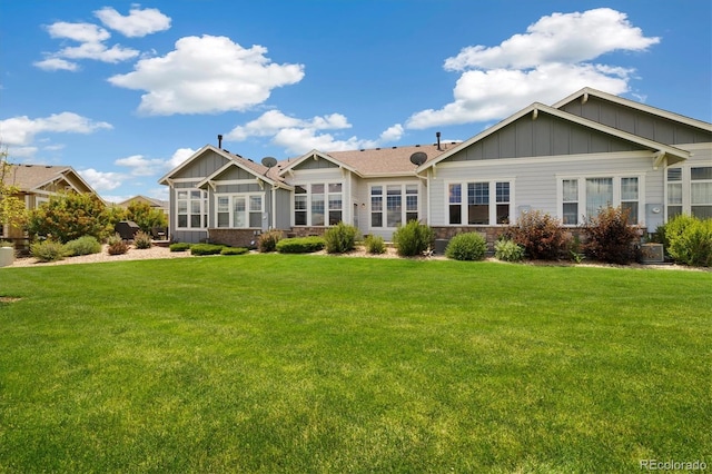 14443 W 88th Dr Unit B, Arvada, CO 80005 - back of property featuring board and batten siding, a yard, and stone siding