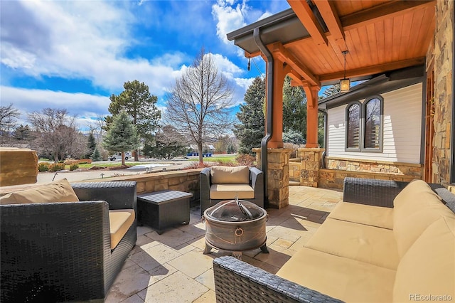 view of patio featuring an outdoor living space with a fire pit