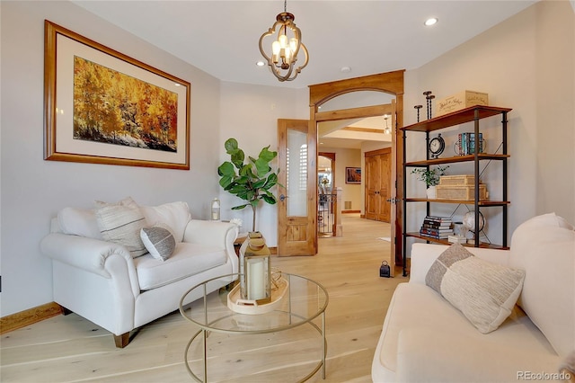 living room with light wood-type flooring and an inviting chandelier