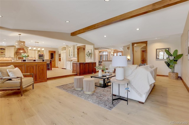 living room featuring light wood-type flooring, lofted ceiling with beams, and a notable chandelier