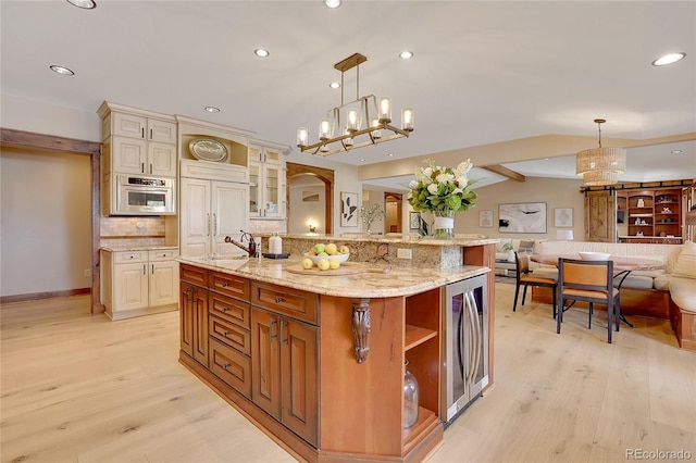 kitchen with vaulted ceiling with beams, a large island, hanging light fixtures, and cream cabinetry